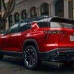 People walking towards a red 2026 Chevy Equinox AWD.