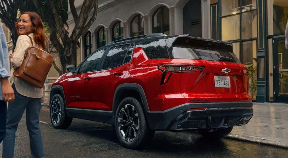People walking towards a red 2026 Chevy Equinox AWD.