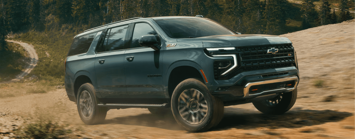 Green 2026 Chevy Suburban Z71 driving up a trail