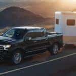 Black 2026 Chevy Silverado 1500 towing a trailer.