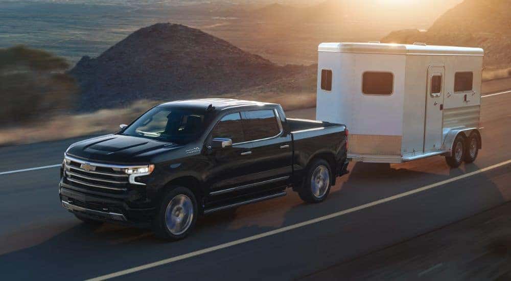 Black 2026 Chevy Silverado 1500 towing a trailer.