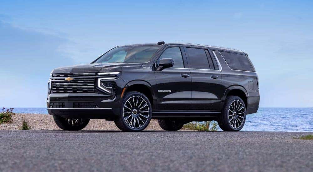 Black 2026 Chevy Suburban High Country parked near a beach.