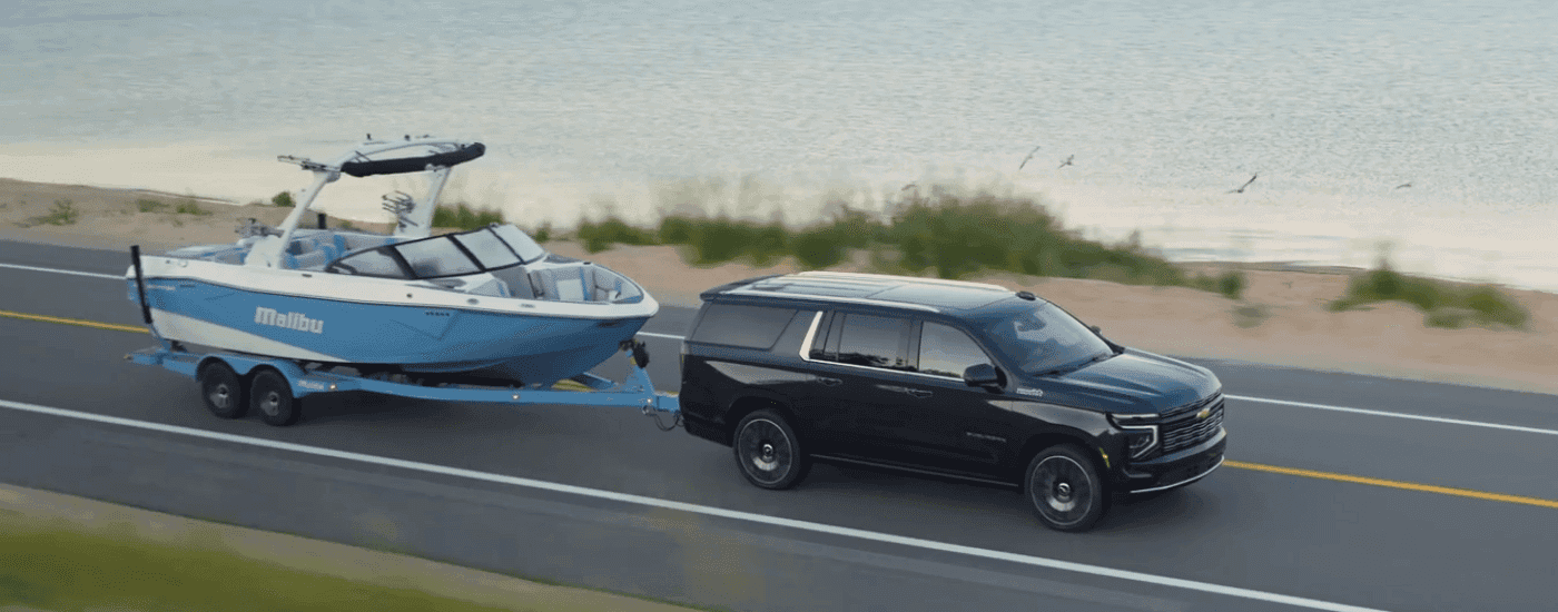 Black 2026 Chevy Suburban High Country towing a boat
