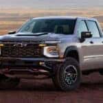 A silver 2027 Chevy Silverado 1500 parked in an open dirt field.