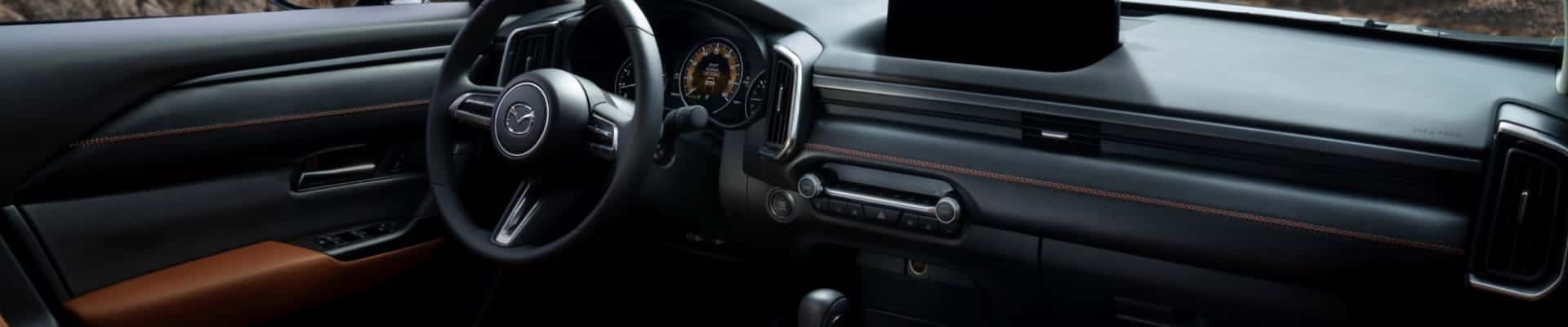 Mazda SUV interior showing the dashboard, steering wheel, and front cabin.