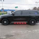 Side profile of a 2025 Dodge Durango police unit featuring lighting and rear flashers.