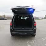 Rear view of a 2025 Dodge Durango patrol SUV with activated warning lights and tinted rear windows.