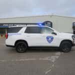 Side profile of a white 2025 Chevy Tahoe police unit with push bumper and full lighting package.