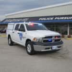 RAM 1500 patrol truck parked outdoors with active warning lights and integrated K9 transport system.