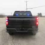 Rear view of a Chevrolet Silverado law enforcement truck with tailgate open showing organized bed drawer storage.