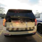 Rear view of three white 2025 Chevrolet Tahoe Fire and EMS units with emergency lighting.