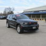 Front three-quarter view of a 2025 Dodge Durango EMS vehicle equipped with emergency lighting, grille lights, and roof-mounted light bar, parked outside a service facility.