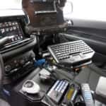 Interior view of a 2025 Dodge Durango police vehicle showing transport partition and mounted control console.