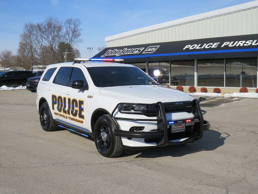Front three-quarter view of a 2025 Dodge Durango patrol vehicle with push bumper and LED warning lights.