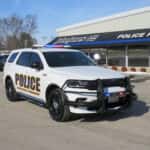 Front three-quarter view of a 2025 Dodge Durango patrol vehicle with push bumper and LED warning lights.