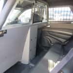 Interior view of a 2025 Dodge Durango police vehicle showing partition and exterior push bumper visible.