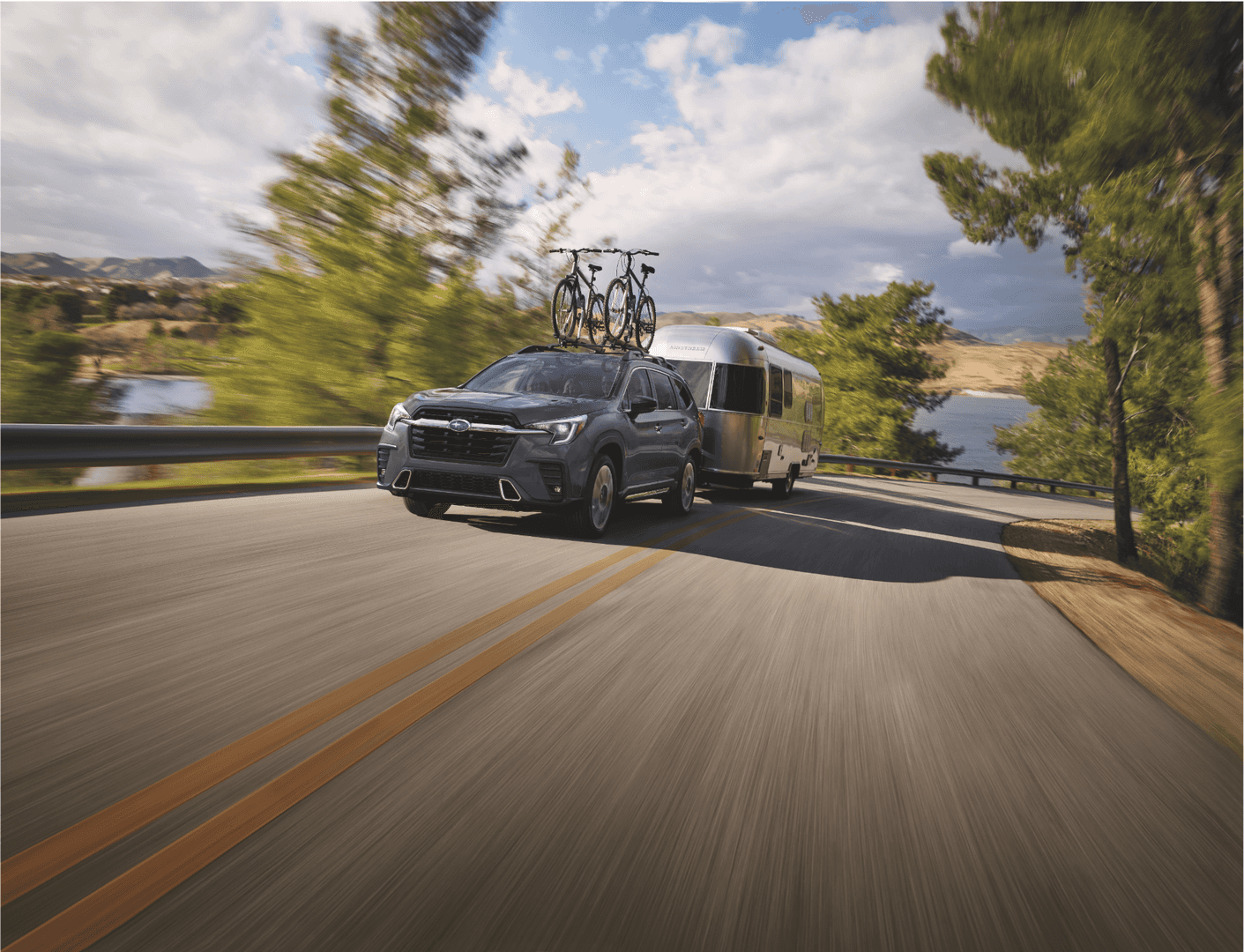 Subaru SUV towing a camper along a scenic road near Juneau, Alaska