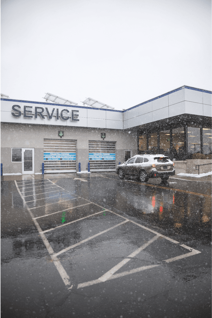 Snow falling on the service drive and service bay doors at Juneau Subaru in winter
