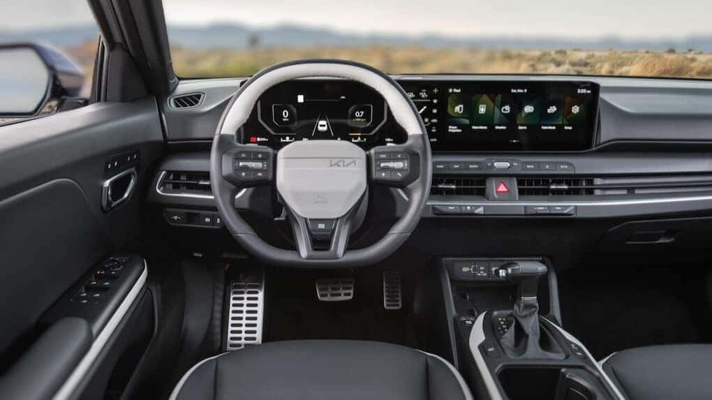 Driver’s cockpit view of the 2025 Kia K4 with digital dashboard and modern steering wheel
