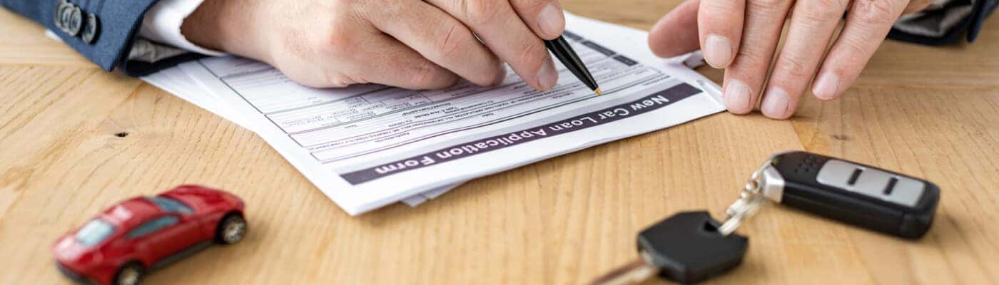Man filling out paperwork to buy a car