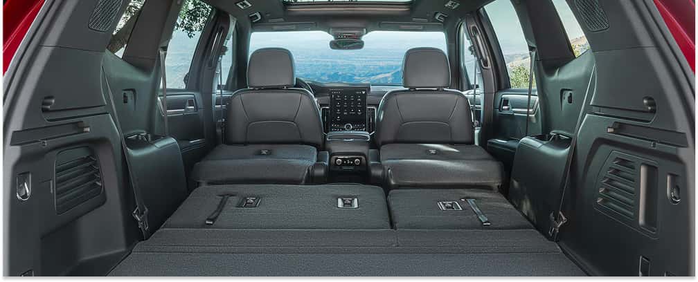 Cargo area of a 2026 GMC Acadia with second and third-row seats folded flat.