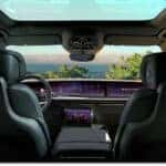Interior view of a 2026 Cadillac Escalade IQL showing black leather front seats, dashboard display, and panoramic roof.