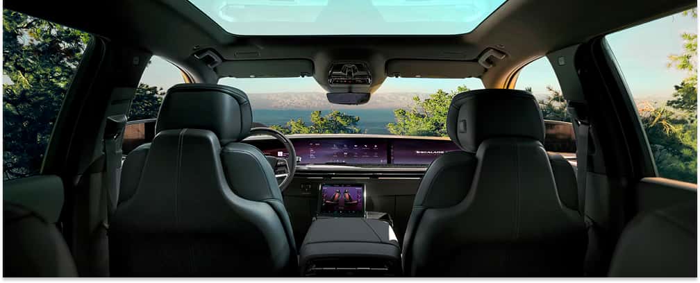 Interior view of a 2026 Cadillac Escalade IQL showing black leather front seats, dashboard display, and panoramic roof.