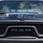 A close up shows the grille and headlights on a black 2024 Ram 1500 after leaving a Ram dealer.