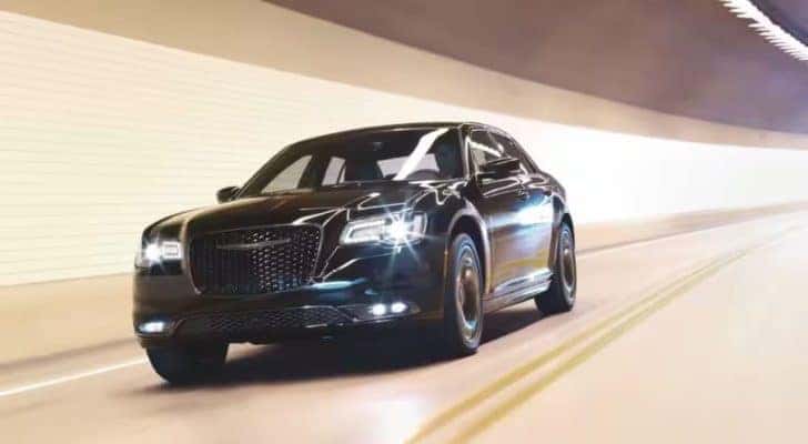 A black 2023 Chrysler 300 is shown driving through a tunnel after leaving a Chrysler dealer.