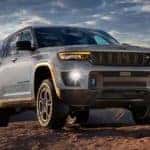 A silver 2024 Jeep Grand Cherokee 4xe is shown off-road.