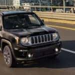 A black 2023 Jeep Renegade is shown driving on a highway.