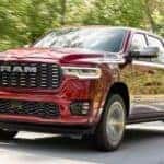 A red 2025 Ram 1500 is shown driving to a Ram dealer near Concord.