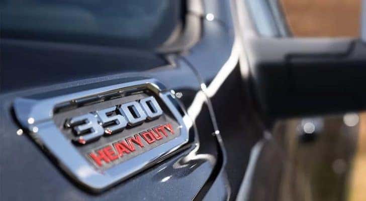 A close-up shows the hood badge of a black 2024 Ram 3500.