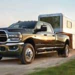 A grey 2024 Ram 3500 is shown towing a trailer.