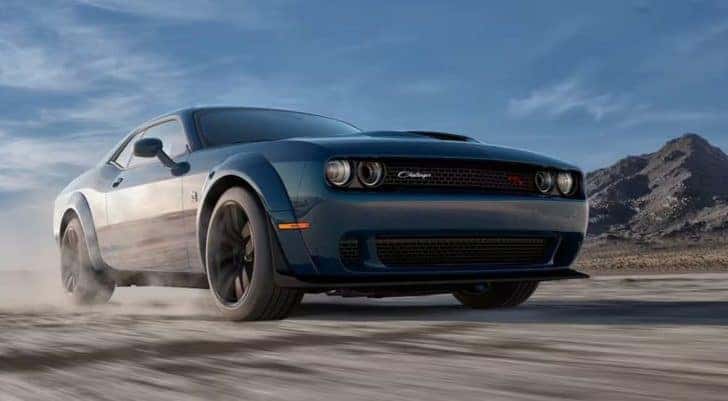 A blue 2023 Dodge Challenger Scat Pack WideBody is shown from the front at an angle after leaving a Dodge Challenger Sales event.