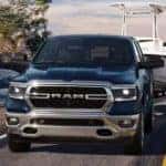 A blue 2024 Ram 1500 Big Horn is shown towing a boat after viewing Ram trucks for sale near Concord.