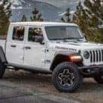 A white 2024 Jeep Gladiator Rubicon for sale is shown parked off-road.