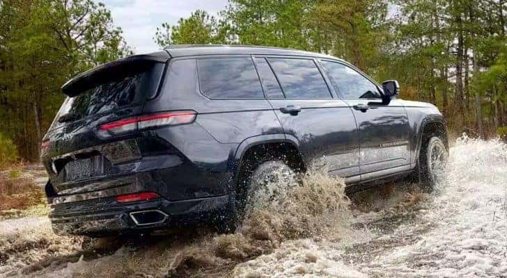 A grey 2024 Jeep Grand Cherokee is shown from the rear at an angle.