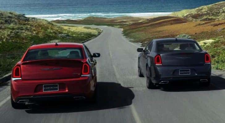 A red and a grey 2023 Chrysler 300 are shown from the rear after leaving a Chrysler dealer near Charlotte.