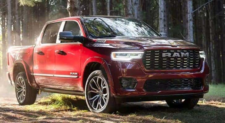 A red 2025 Ram 1500 Tungsten parked in the woods.