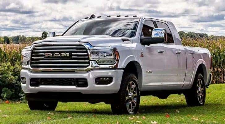 A white 2024 Ram 2500 parked off-road by a wheat field.