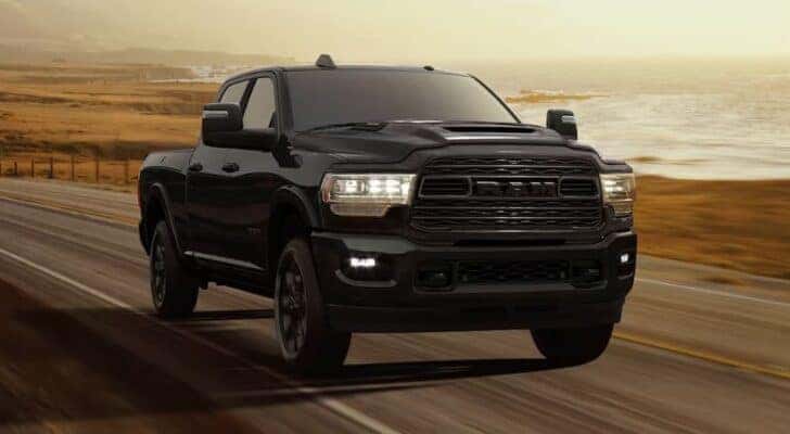 A black 2024 Ram 3500 Tradesman Night Edition is shown driving to view a Ram 3500 for sale near Charlotte.