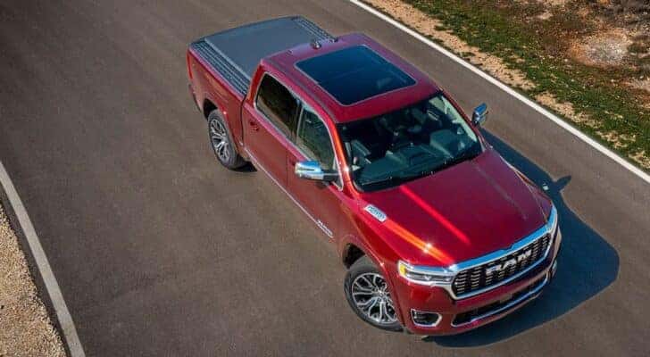 A red 2025 Ram 1500 Tungsten for sale near Charlotte is parked at a dealership.
