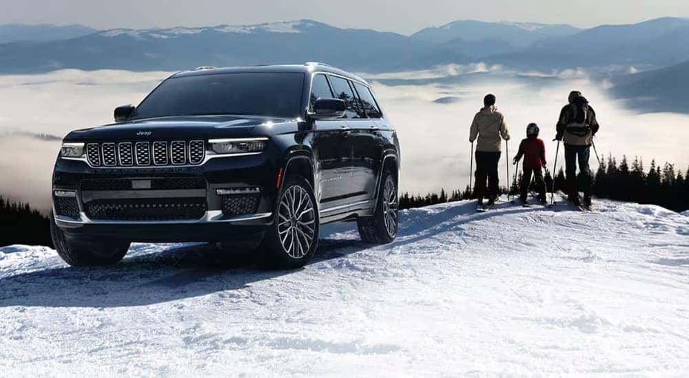 A black 2025 Jeep Grand Cherokee Summit is shown from the front at an angle.