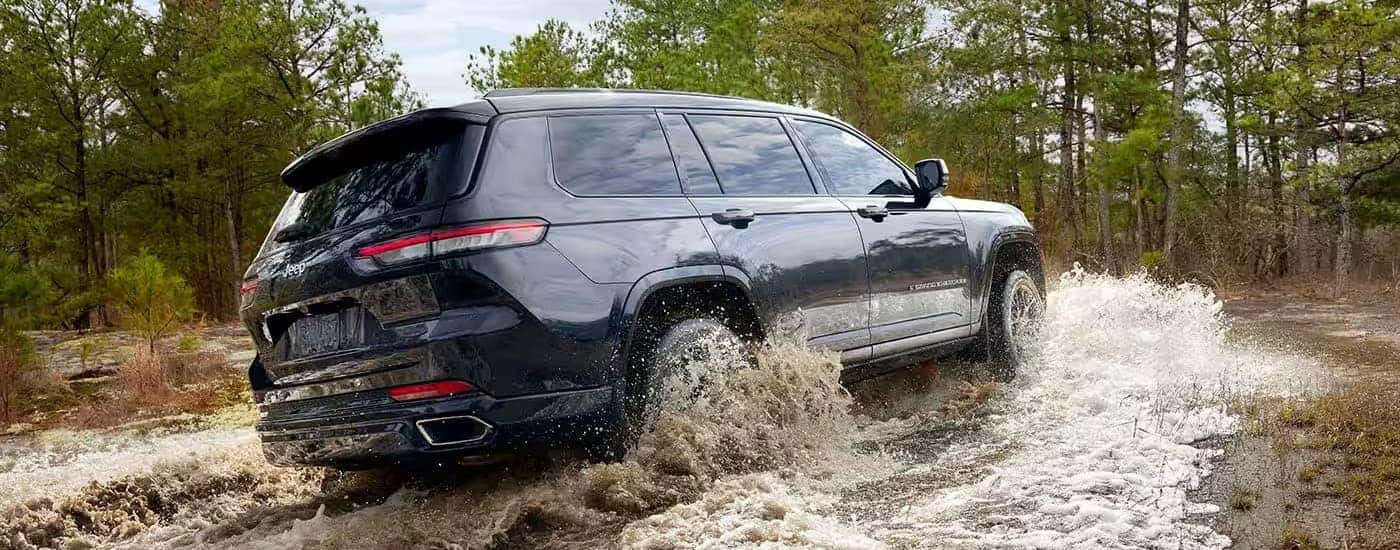A dark blue 2024 Jeep Grand Cherokee L is shown from the rear at an angle.