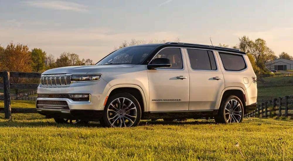 A white 2025 Jeep Grand Wagoneer parked in a grassy field.