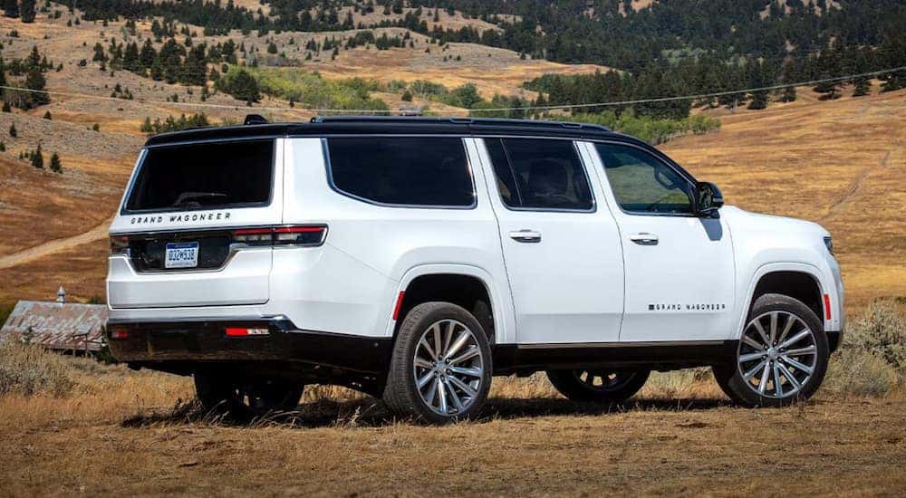 Rear view of a white 2025 Jeep Grand Wagoneer parked off-road.