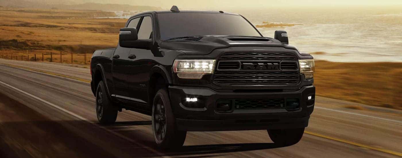 A black 2024 Ram 3500 driving from a Ram dealer near Statesville.