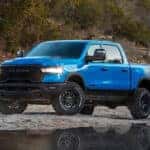 A blue 2025 Ram 1500 Rebel is shown from the front at an angle.