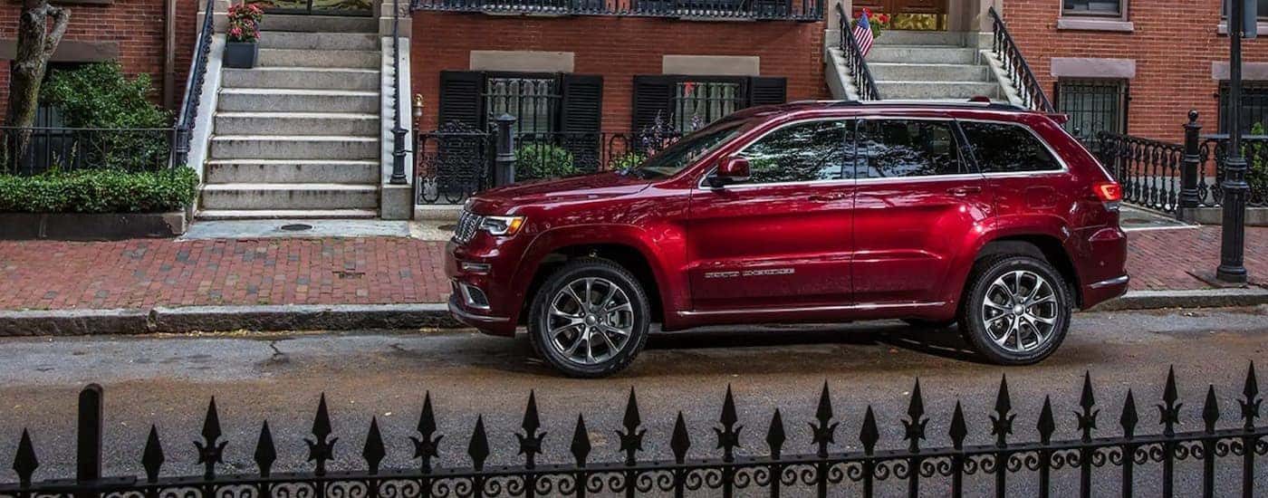 A red 2021 Jeep Grand Cherokee parked near a curb.